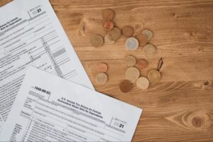 Tax forms and scattered coins representing recoverable Sales & Use Tax overpayments and spend management opportunities