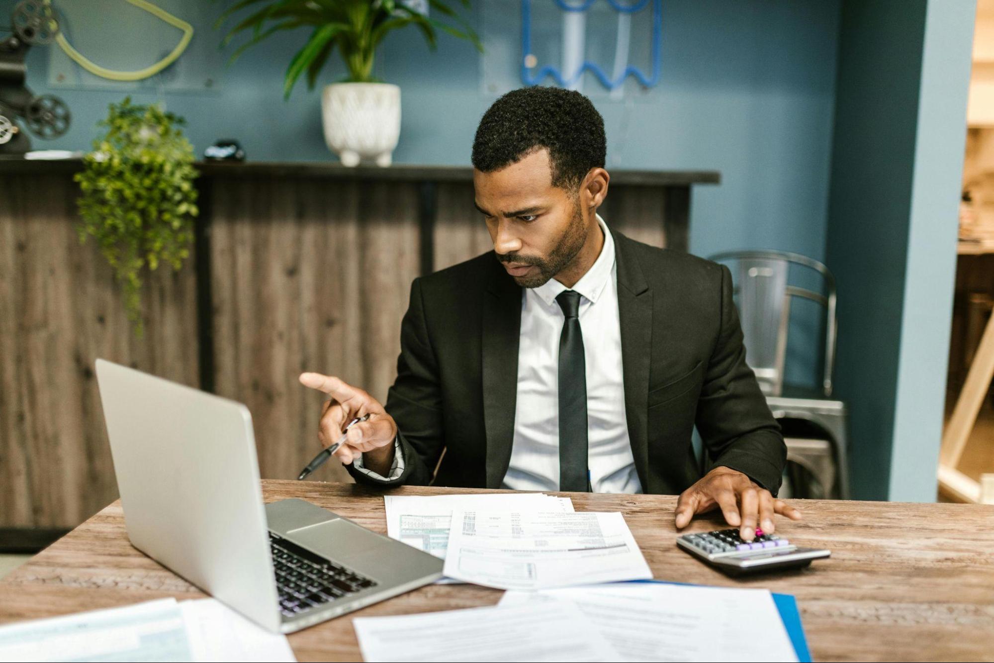 CFO reviewing financial documents and tax records in his office as part of a cost reduction consulting review