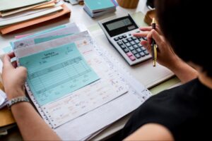 Finance professional reviewing invoices and payment records to identify overpayments with cost reduction consultants.