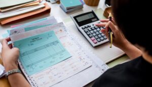 Finance professional reviewing invoices and payment records to identify overpayments with cost reduction consultants.