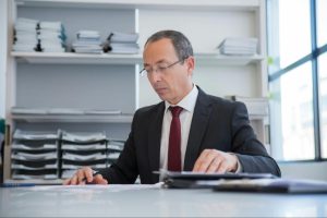 CFO reviewing invoices and financial reports during quarterly review to identify cash flow gaps and hidden cost inefficiencies.