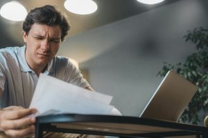 Procurement professional comparing vendor pricing across multiple screens with spreadsheets, charts, and contract documents to benchmark costs and identify savings opportunities.