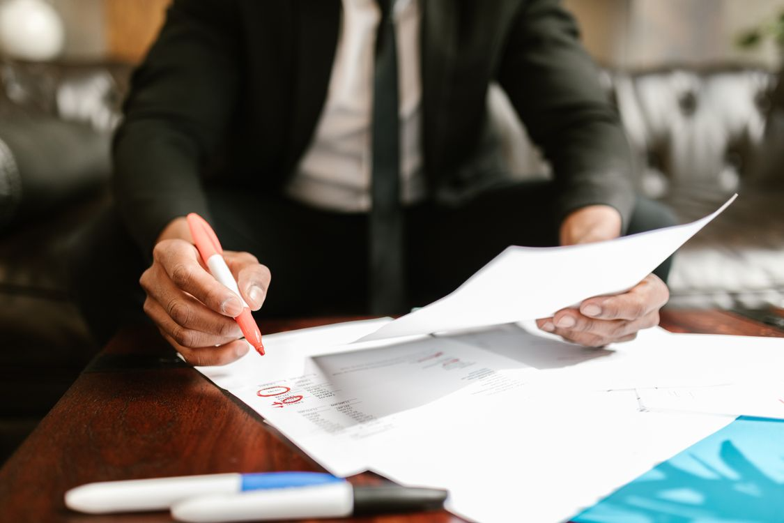 Finance professional overwhelmed by paperwork, illustrating the challenges and hidden costs of manual invoicing in accounts payable.