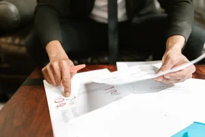 Finance professional reviewing invoices and financial documents, identifying billing discrepancies and potential overcharges during an invoice audit to reduce operational costs.