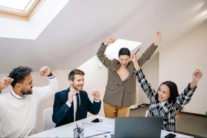 A happy operations team celebrating improved cost control and restored profitability after working with The SALT Group’s cost reduction services.