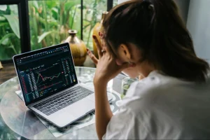 Emma Carter, operations director, frustrated while reviewing rising freight and merchant costs on a laptop in a multi-location business setting