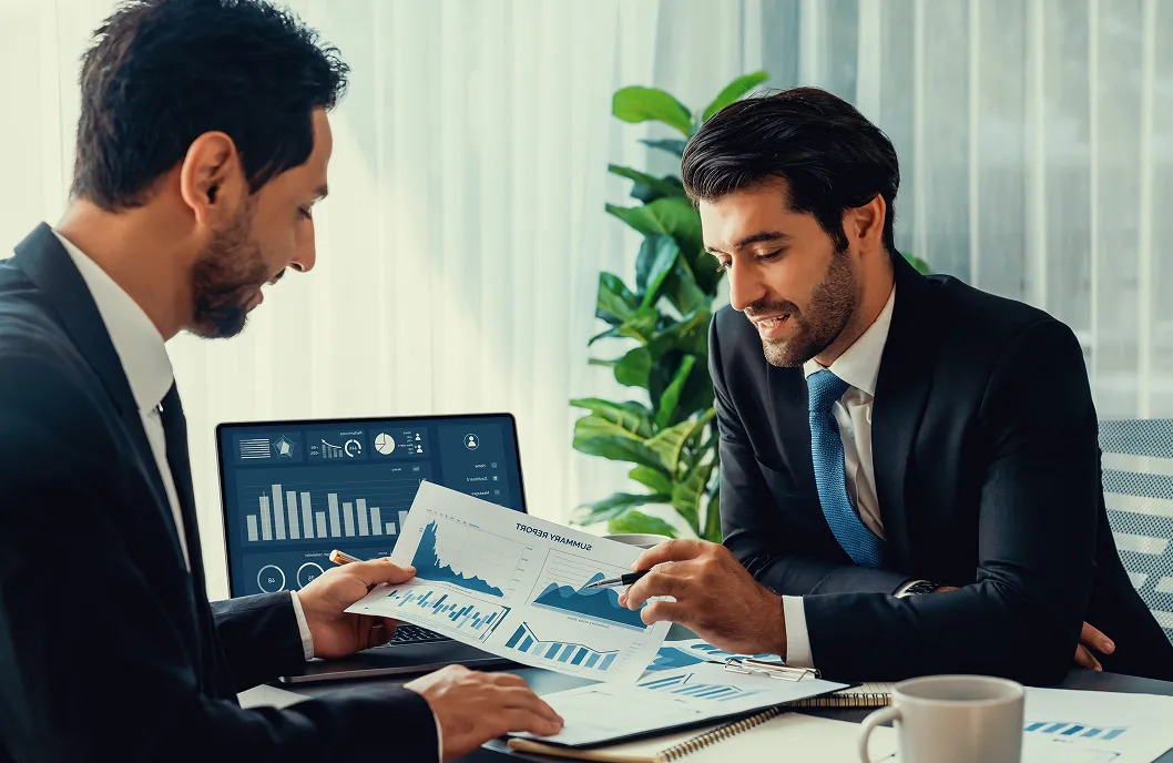 two-men-suits-discuss-financial-report