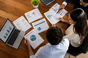 Three professionals reviewing budget, expense, and savings reports for business spend control.