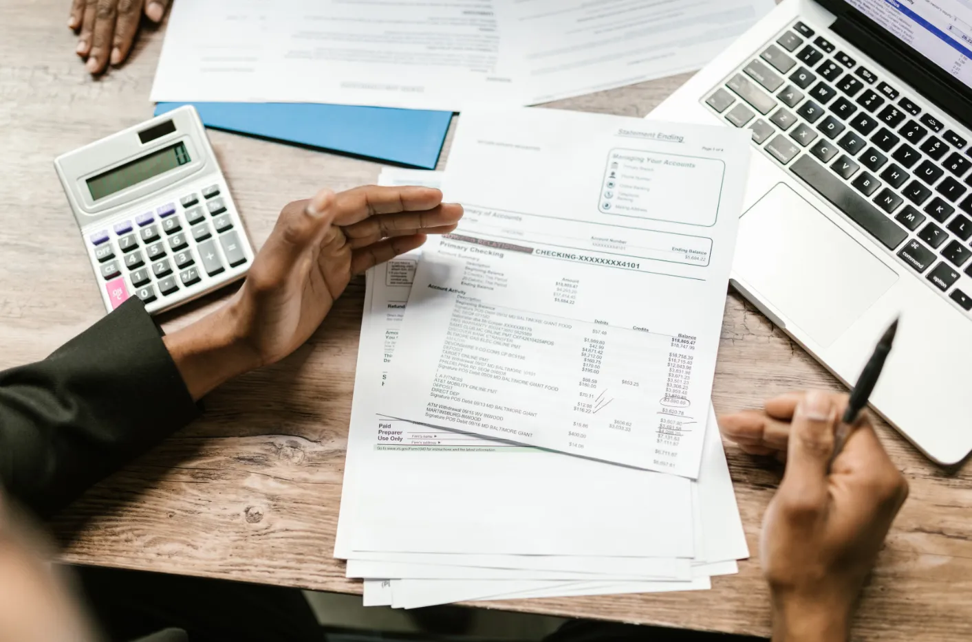 Finance professionals reviewing financial statements and expenses for manufacturing cost reduction.