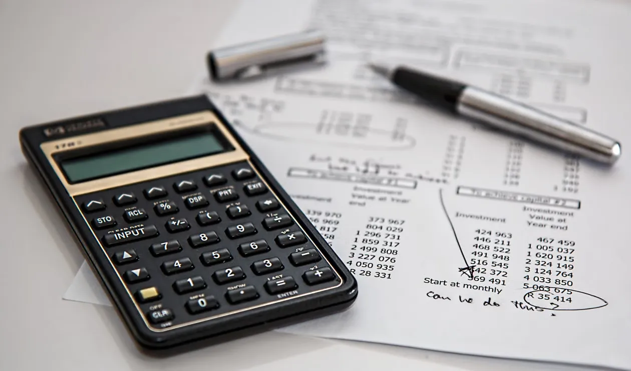 Calculator and financial documents illustrating supplier spend analysis and cost review.